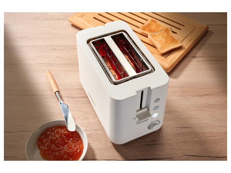 Un grille-pain blanc Cuisinart avec du pain grillé et de la confiture.