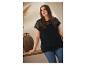 Femme portant un t-shirt noir avec des détails en dentelle et un jean.