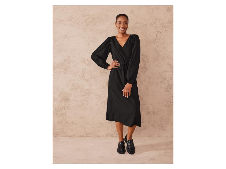 Une femme portant une robe noire et des mocassins noirs.