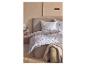 Chambre avec un lit doté d'une housse de couette et d'oreillers à motif de feuilles bleues et blanches.