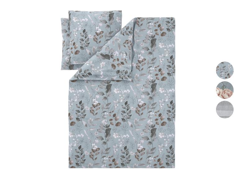 Parure de lit avec motif de feuilles et de fleurs dans des tons gris et marron sur fond bleu.