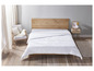 Une couette blanche sur un cadre de lit en bois dans une chambre à coucher.