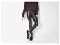 Femme en pull marron, leggings en similicuir noir et mocassins marron foncé