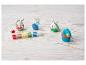 Kit de peinture de Pâques avec lapins en céramique, pots de peinture et pinceaux sur une surface en bois.