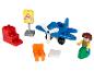 Un avion jouet bleu avec des hélices, des blocs, une chaise et une figurine.