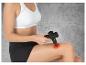 Une femme utilise un pistolet de massage sur sa cuisse.