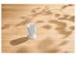 Coquetier blanc sur une table en bois clair avec des ombres de feuilles.