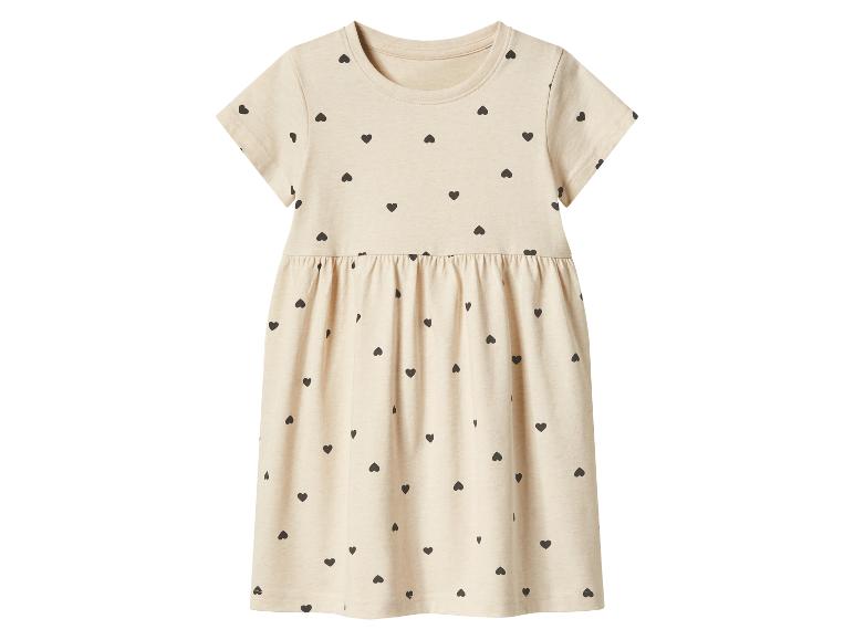 Robe enfant beige à manches courtes avec des cœurs noirs.