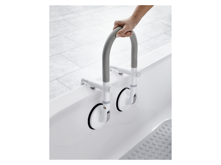 Une personne tient une poignée de douche à ventouses dans une baignoire.