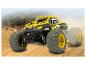 Une voiture télécommandée Extron jaune et noire dans le sable.