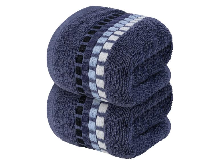 Deux serviettes bleu foncé avec un motif géométrique.