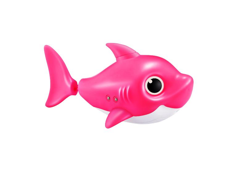 Jouet requin rose aux grands yeux sur fond blanc.