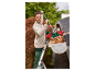 Femme nettoyant une gouttière avec le balai télescopique angulaire PARKSIDE®, plein de feuilles.