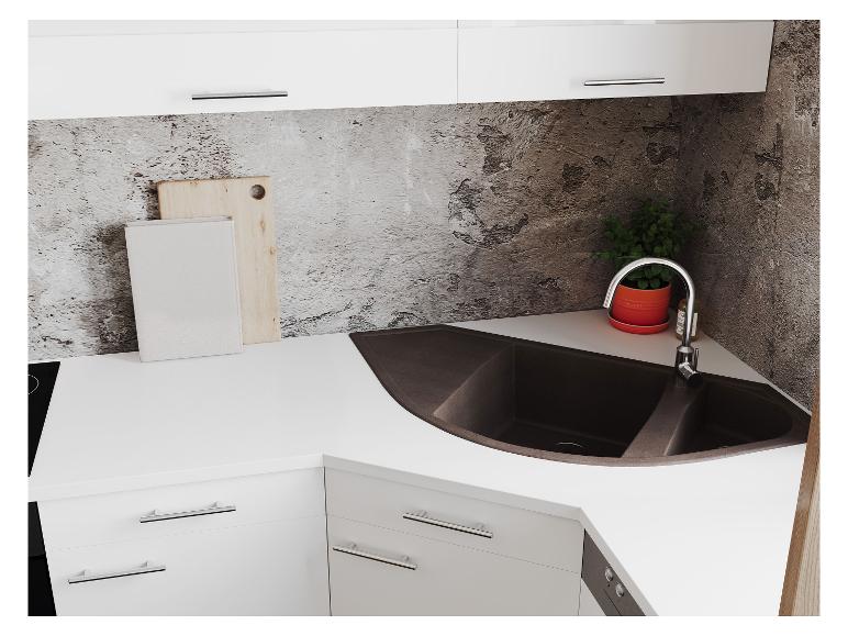 Plan de travail de cuisine blanc avec évier d'angle, planches à découper et plante.