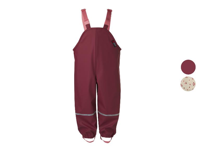 Salopette de pluie bordeaux pour enfant avec bretelles roses et détails réfléchissants.