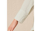 La manche d'une chemise beige clair à boutons.