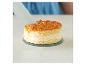 Un couteau coupe un gâteau rond avec un glaçage aux amandes.