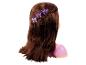 Poupée aux cheveux longs et bruns, coiffée d'une tresse et de pinces à cheveux violettes en forme de couronne.