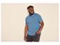 Homme souriant portant un polo bleu et un jean foncé, la main dans la poche.