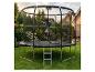 Enfant sautant sur un grand trampoline avec filet de sécurité dans un jardin.