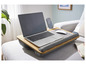 Un ordinateur portable, un téléphone et une souris sur une table en bois avec un coussin.