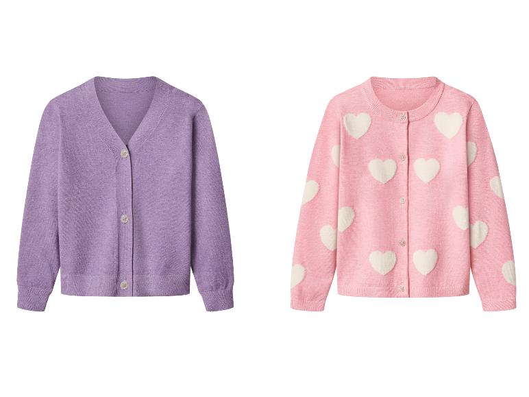 Deux cardigans : un violet uni à col en V et un rose à col rond avec des cœurs blancs.