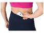 Une femme range son téléphone dans la poche de son legging de sport.
