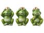 Trois figurines de grenouilles vertes avec des couronnes dorées, représentant 'ne rien entendre, ne rien voir, ne rien dire'