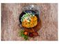 Curry avec riz et épices dans une poêle noire sur une table en bois.