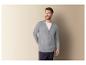 Un homme porte un cardigan gris et un t-shirt blanc.