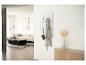 Un salon moderne avec un canapé beige, une table basse noire et un porte-manteau blanc avec une robe grise.
