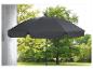 Un parasol noir dans un jardin vert.