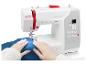 Machine à coudre blanche avec fil rouge, cousant un tissu bleu.