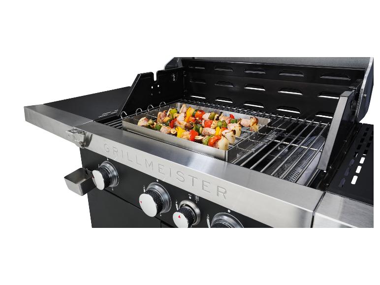 Barbecue au gaz Grillmeister avec des brochettes de viande et de légumes grillés