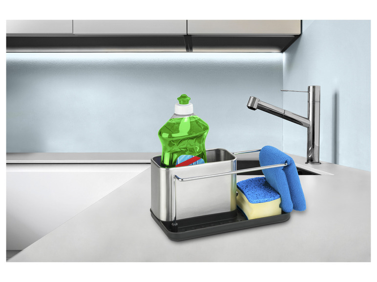 Un évier de cuisine avec un support en métal pour le liquide vaisselle, l'éponge et la serviette.