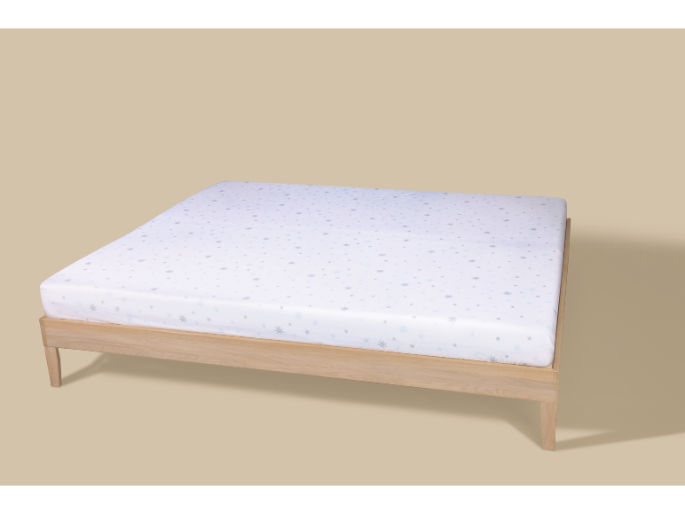Drap-housse à motif flocons de neige sur un cadre de lit en bois