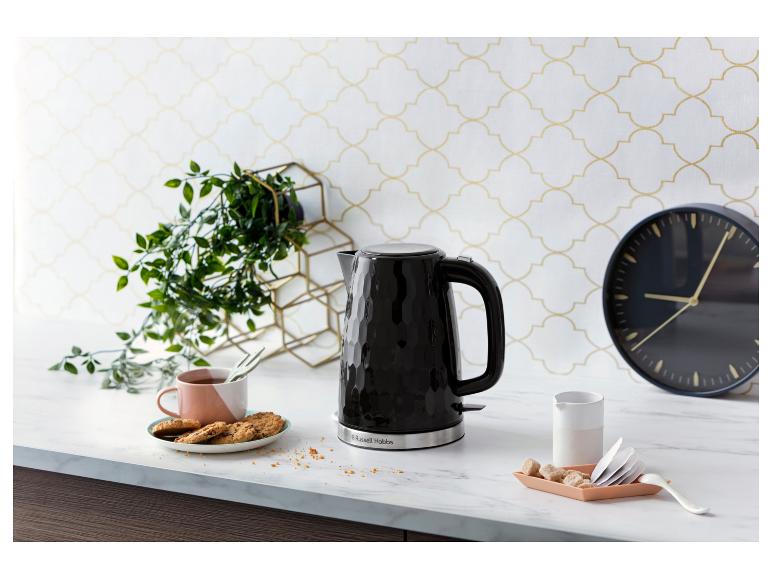 Une bouilloire Russell Hobbs noire sur un comptoir en marbre.