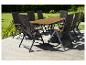 Ensemble de salle à manger extérieur avec table en bois et huit chaises en osier foncé sur une terrasse en bois.