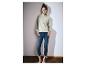 Femme en sweat à capuche vert clair zippé et jean.
