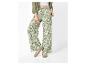 Pantalon femme à imprimé floral, chemise verte et baskets blanches.