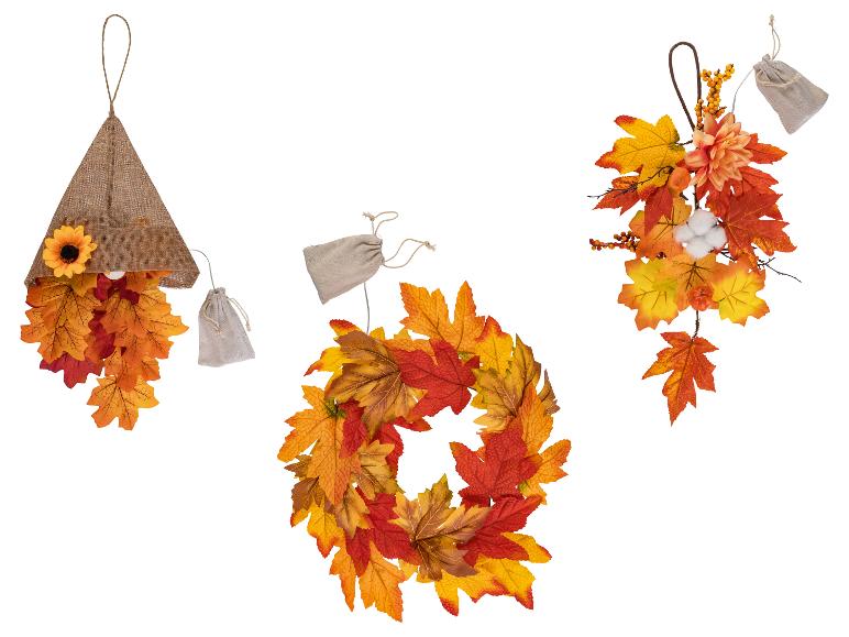Décorations d'automne avec feuilles d'érable, tournesol et baies, y compris une couronne et des suspensions.