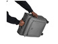 Une main tenant une valise grise à roulettes.