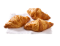 Trois croissants dorés sur un linge blanc.