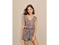 Une femme porte une combinaison bleue à imprimé floral.