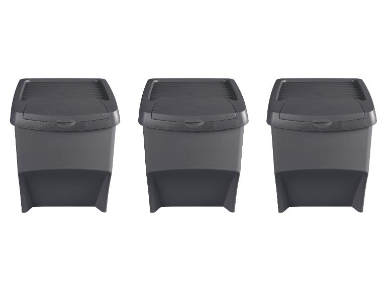 Trois poubelles gris foncé avec couvercles basculants, alignées.