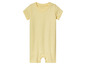 Une grenouillère jaune pour bébé avec des étoiles blanches.