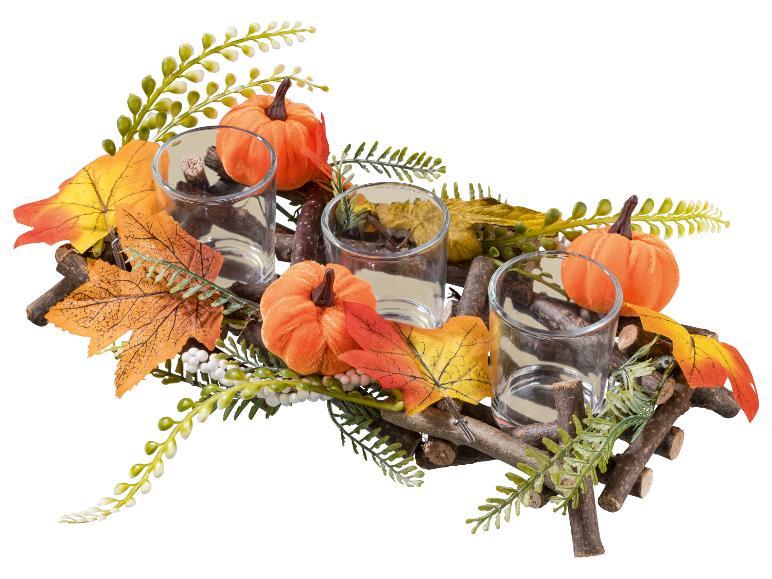 Décoration d'automne avec trois photophores, citrouilles et feuilles