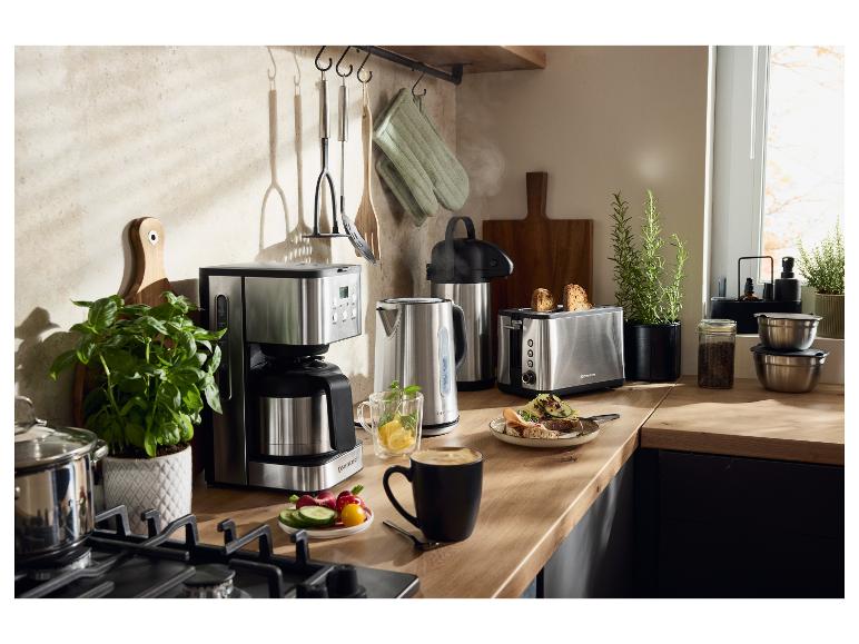 Comptoir de cuisine avec cafetière, bouilloire et grille-pain en acier inoxydable.
