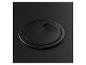 Passe-câble rond noir intégré dans une surface sombre.