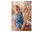 Un bébé en salopette joue avec des jouets en bois dans un tipi.